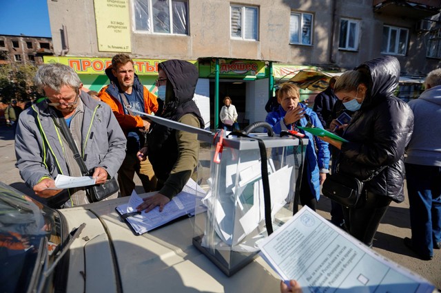 Penduduk setempat memberikan suaranya pada hari ketiga referendum tentang bergabungnya Republik Rakyat Donetsk ke Rusia, di Mariupol, Ukraina, Minggu (25/9/2022). Foto: Alexander Ermochenko/REUTERS