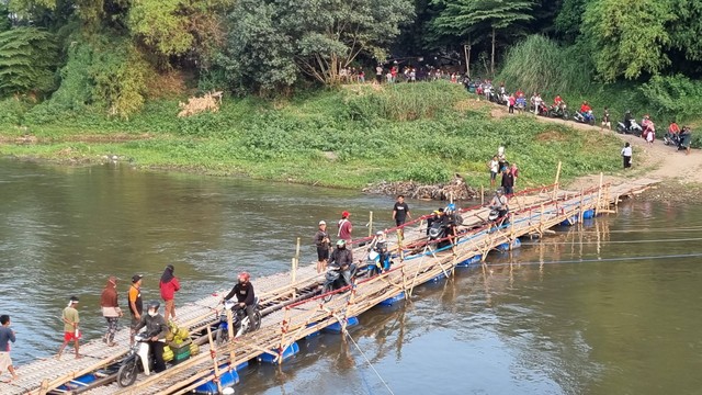 Tak hanya pengendara sepeda motor, pejalan kaki pun turut memanfaatkan jembatan sesek atau jembatan bambu, Senin (26/09/2022). FOTO: Fernando Fitusia.
