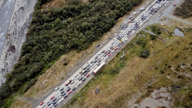 Antrean kendaraan mulai dari mobil hingga truk mengular di dekat perbatasan Rusia dengan Georgia, Minggu (25/9/2022). Foto: The Insider via Reuters
