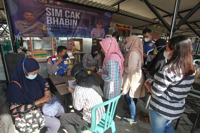 Sejumlah warga mengantre untuk mengajukan permohonan Surat Ijin Mengemudi (SIM) dalam program SIM Cak Bhabin di Pasar Gunung Anyar, Surabaya, Jawa Timur, Selasa (27/9). Foto: Didik Suhartono/ANTARA FOTO