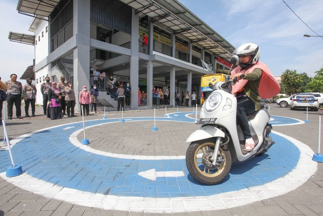 Warga mengikuti ujian praktek Surat Ijin Mengemudi (SIM) dalam program SIM Cak Bhabin di Pasar Gunung Anyar, Surabaya, Jawa Timur, Selasa (27/9). Foto: Didik Suhartono/ANTARA FOTO