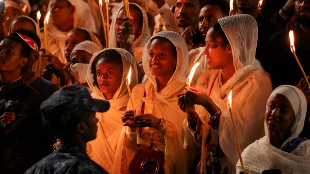 Umat Ortodoks Ethiopia memegang lilin selama perayaan festival Meskel untuk memperingati penemuan salib sejati tempat Yesus Kristus disalibkan, di alun-alun Meskel, di Addis Ababa, Ethiopia, Senin (26/9/2022). Foto: Tiksa Negeri/REUTERS