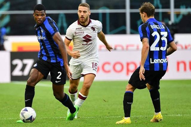 Pemain Inter Milan Denzel Dumfries berusaha melewati pemain Torino pada pertandingan lanjutan Liga Italia di Stadion San Siro, Milan, Italia. Foto: Isabella BONOTTO / AFP