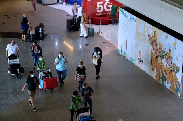 Sejumlah penumpang pesawat membawa barang bawaannya di area Terminal Internasional Bandara I Gusti Ngurah Rai, Badung, Bali, Kamis (29/9/2022). Foto: Fikri Yusuf/ANTARA FOTO