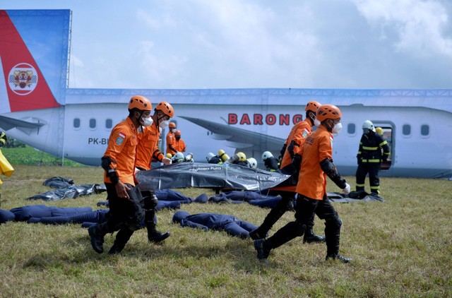 Sejumlah petugas mengevakuasi korban kecelakaan pesawat saat pelaksanaan simulasi penanganan keadaan darurat di Bandara Internasional I Gusti Ngurah Rai, Badung, Bali, Kamis (29/9/2022). Foto: Fikri Yusuf/ANTARA FOTO