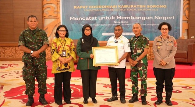 Penjabat Bupati Sorong yang didampingi Kepala BPS Kabupaten Sorong dan TNI/Polri pose bersama pada rapat koordinasi.