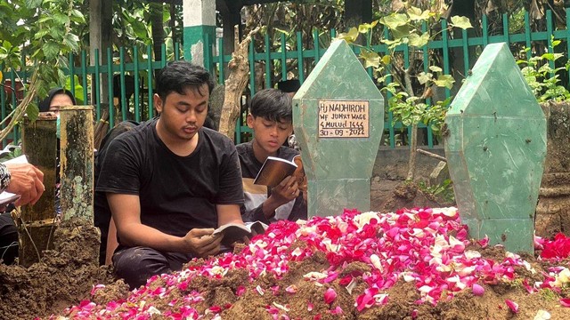 Anak pertama Nadhiroh, Ali Akbar Nafiez berdoa di makan ibundanya, di Kecamatan Genuk pada Jumat (30/9/2022). Foto: Intan Alliva Khansa/kumparan