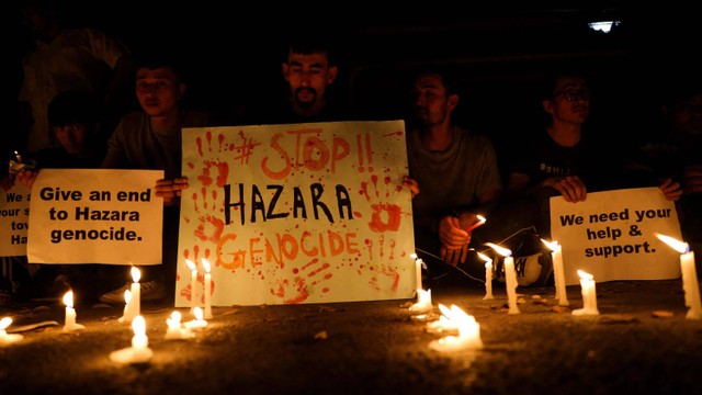 Warga negara Afghanistan, anggota minoritas Hazara, memegang plakat dan lilin saat mereka memprotes serangan bunuh diri di sebuah pusat bimbingan belajar di Kabul barat, di luar kantor UNHCR di New Delhi, India, Jumat (30/9/2022). Foto: Anushree Fadnavis/REUTERS