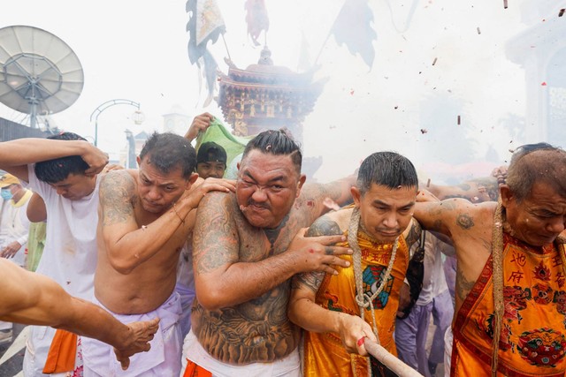 Orang-orang mengikuti prosesi Kuil Bang Neow selama festival vegetarian tahunan, di Phuket, Thailand, Sabtu (1/10/2022). Foto: Jorge Silva/REUTERS
