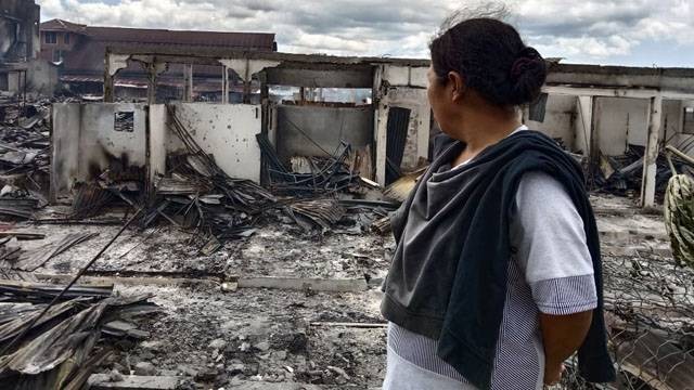 Anong Dunggio hanya bisa terpaku melihat kios jualan makan di Pasar 54 Amurang, Minahasa Selatan terbakar.