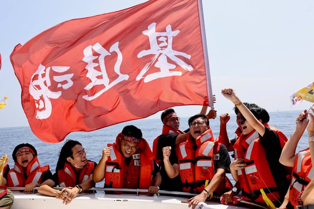 Chen Yi-chi, ketua Partai Pembangunan Negara Taiwan yang pro-kemerdekaan memimpin anggotanya menyanyikan lagu pesta dalam perjalanan perahu di Selat Taiwan di Kaohsiung, Taiwan, Sabtu (1/10/2022). Foto: Ann Wang/REUTERS
