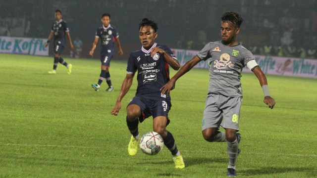 Pesepak bola Arema FC Arkhan Fikri (kiri) berebut bola dengan pesepak bola Persebaya Surabaya Muhammad Alwi Slamat (kanan) dalam pertandingan lanjutan BRI Liga 1 di Stadion Kanjuruhan, Malang, Jawa Timur, Sabtu (1/10/2022). Foto: Ari Bowo Sucipto/ANTARA FOTO