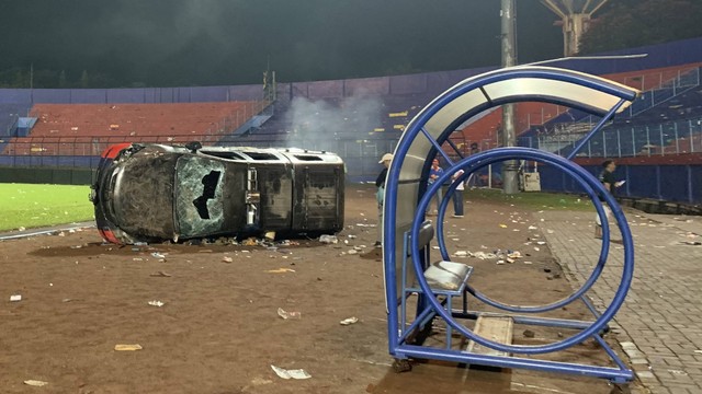 Sebuah mobil polisi terbalik akibat kericuhan usai pertandingan BRI Liga 1 antara Arema melawan Persebaya di Stadion Kanjuruhan, Malang, Jatim, Minggu (2/10/2022). Foto: ANTARA FOTO/H Prabowo