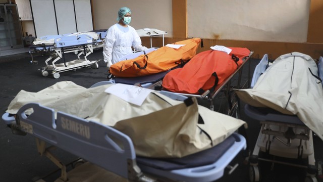 Seorang petugas medis memasang tanda pengenal pada tubuh korban injak sepak bola di Rumah Sakit Saiful Anwar Malang, Jawa Timur, Indonesia, Minggu, 2 Oktober 2022. Foto: AP/Trisnadi