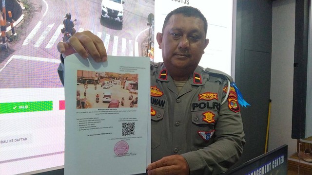 Kanit Gakkum Satlantas Polresta Bandar Lampung, Ipda Gunawan saat menunjukkan surat konfirmasi tilang ETLE. | Foto: Bella Sardio/Lampung Geh