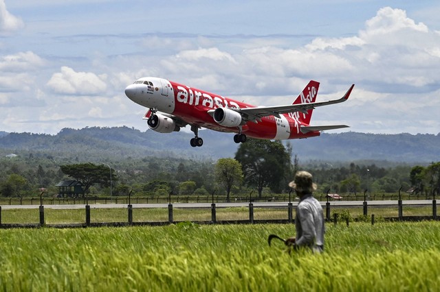 Pesawat penumpang AirAsia tiba dari Malaysia untuk pertama kalinya setelah sempat terhenti hampir tiga tahun akibat pandemi Covid-19, di Bandara Internasional Sultan Iskandar Muda, Blang Bintang, Aceh, Senin (3/9/2022). Foto: Chaideer Mahyuddin/AFP