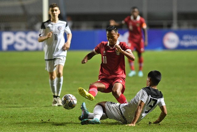 Pesepak bola Tim Nasional U-17 Indonesia Riski Afrisal (atas) berebut bola dengan pesepak bola Tim Nasional U-17 Guam Nicholas Moore (bawah) dalam laga Grup B Kualifikasi Piala Asia U-17 2023 di Stadion Pakansari, Cibinong. Foto: Aditya Pradana Putra/ANTARA FOTO