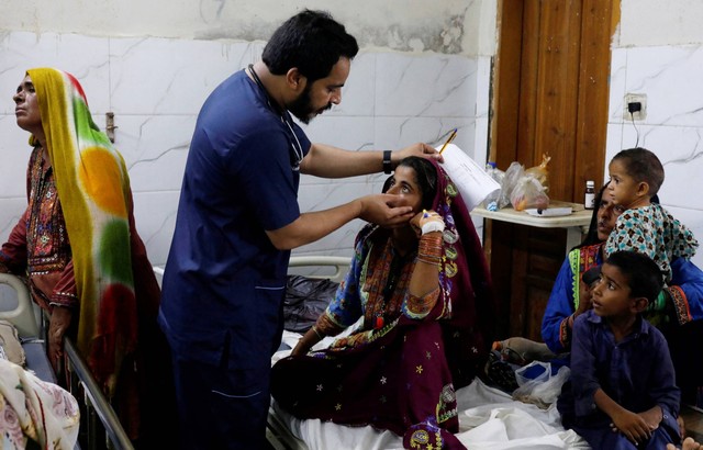 Dokter Naveed Ahmed memberikan bantuan medis kepada korban banjir yang menderita malaria, di koridor di Institut Ilmu Kedokteran Sayed Abdullah Shah di Sehwan, Pakistan, Kamis (29/9/2022). Foto: Akhtar Soomro/REUTERS