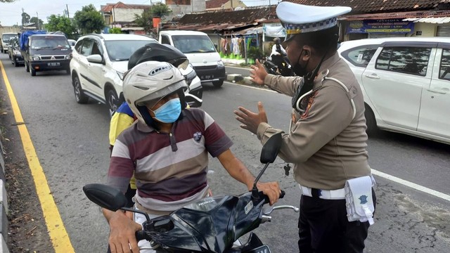 Seorang polisi sedang menilang pengendara motor yang masuk ke jalur cepat di Ringroad. Foto: istimewa