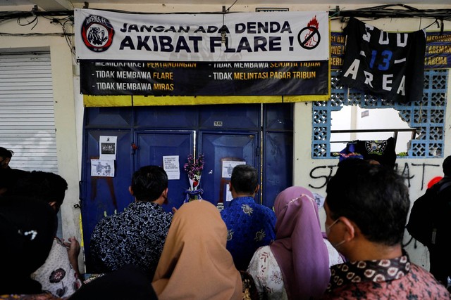Warga berdoa di luar gerbang masuk Stadion Kanjuruhan, Malang, Jawa Timur, untuk memberikan belasungkawa kepada para korban kerusuhan, Selasa (4/10/2022). Foto: Willy Kurniawan/REUTERS