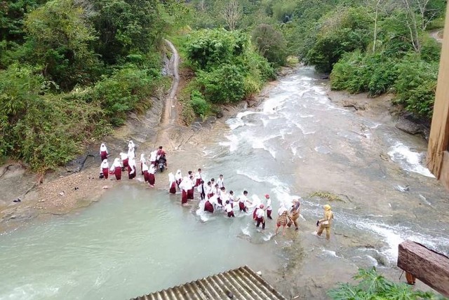 Pelajar di Desa Neglasari, Cianjur, menyebrangi sungai menuju ke sekolah, Selasa (4/10/2022). Foto: Dok. Istimewa