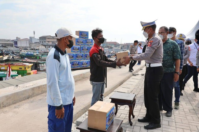 Kasubdit Dakgar Korlantas Polri, Kombes Pol Karsiman, membagikan bantuan paket sembako kepada nelayan pesisir utara, Kelurahan Kalibaru, Kecamatan Cilincing, Jakarta Utara. Foto: Dok. Istimewa