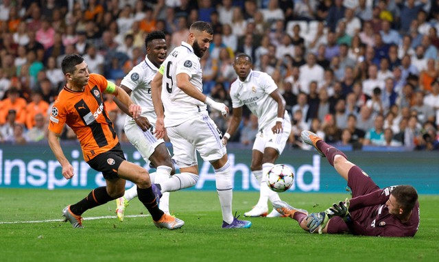 Taras Stepanenko dan Anatolii Trubin dari Shakhtar Donetsk duel dengan Karim Benzema dan Vinicius Junior dari Real Madrid pada pertandingan Liga Champions di Santiago Bernabeu, Madrid, Spanyol. Foto: Susana Vera/Reuters