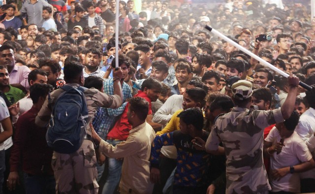 Petugas pasukan paramiliter mengatur kerumunan ketika orang-orang menunggu untuk menonton selebriti selama perayaan festival Vijaya Dashmi atau Dussehra di kawasan tua Delhi, India, Rabu (5/9/2022). Foto: Anushree Fadnavis/Reuters