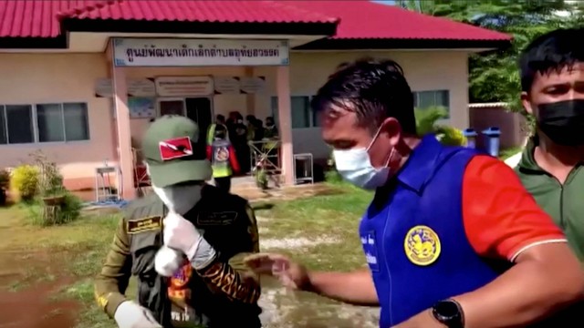 Petugas dan pihak berwenang menjaga gerbang pusat penitipan anak saat orang menunggu, setelah penembakan massal di pusat penitipan anak di kota Uthai Sawan, di provinsi Nong Bua Lamphu, Thailand, Kamis (6/10/2022). Foto: TPBS/ReutersTV via REUTERS