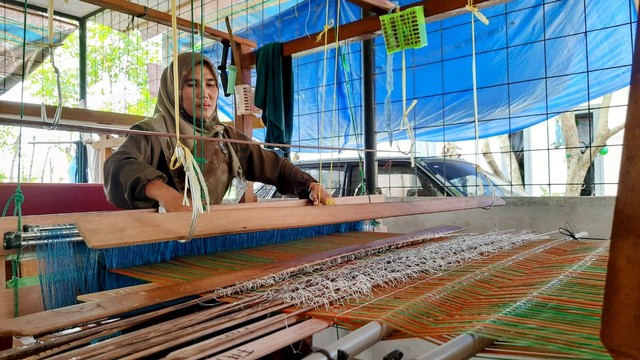 Fitriani, perempuan yang telah menenun sejak 2019 di Mutiara Songket, Gampong Krueng Kalee, Kecamatan Darussalam, Aceh Besar, Jumat (7/10/2022) sore. Foto: Habil Razali/acehkini