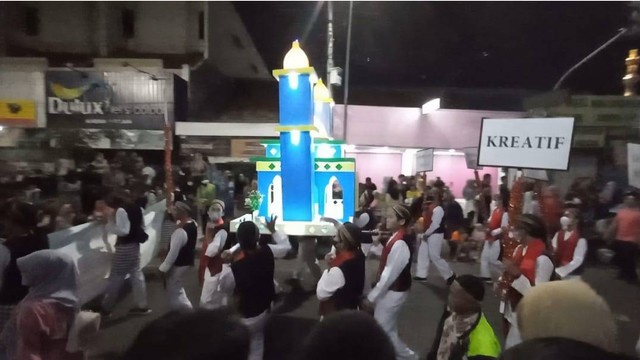 Warga menyaksikan pawai Rolasan memperingati Maulid Nabi Muhammad SAW di Kota Tegal, Jumat (7/10/2022) malam.