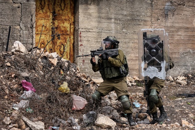 Tentara Israel dikerahkan di tengah bentrokan dengan demonstran Palestina saat protes terhadap pengambilalihan tanah Palestina oleh Israel di desa Kfar Qaddum di Tepi Barat, pada Jumat (7/10/2022). Foto: Ronaldo Schemidt/AFP