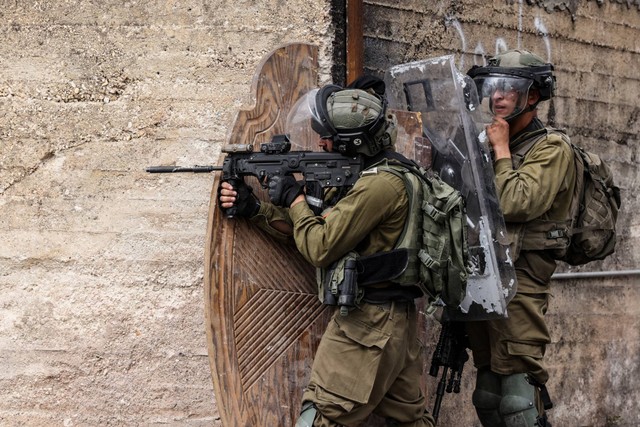 Tentara Israel dikerahkan di tengah bentrokan dengan demonstran Palestina saat protes terhadap pengambilalihan tanah Palestina oleh Israel di desa Kfar Qaddum di Tepi Barat, pada Jumat (7/10/2022). Foto: Ronaldo Schemidt/AFP