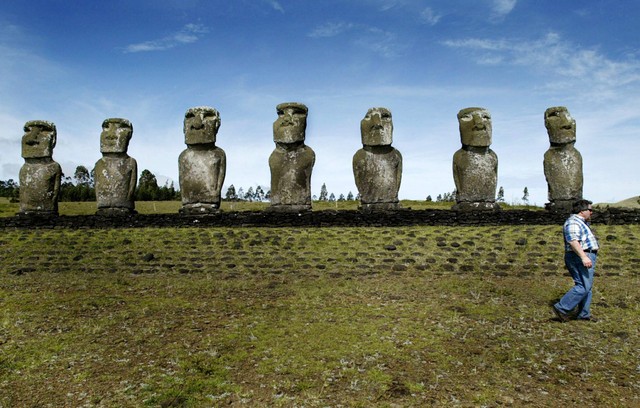 Seorang turis berjalan di sebelah patung "Moai" di Pulau Paskah, 4.000 Km (2.400
mil) barat Santiago. Foto: REUTERS/Carlos Barria