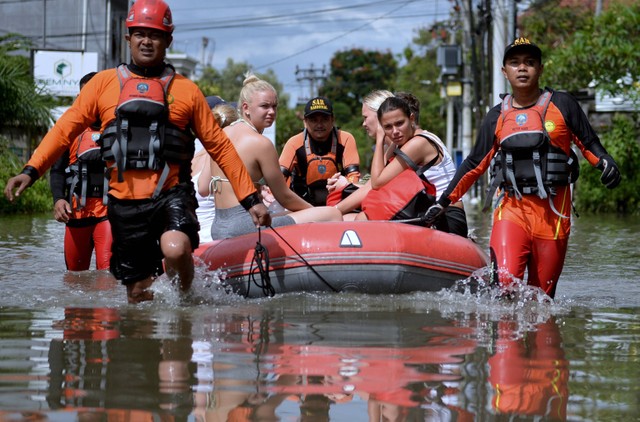 Tim SAR mengevakuasi wisatawan mancanegara (wisman) menggunakan perahu karet saat terjebak banjir di kawasan Seminyak, Badung, Bali, Sabtu (8/10/2022). Foto: ANTARA FOTO/Fikri Yusuf