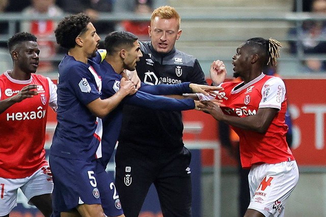 Pemain Paris St Germain Achraf Hakimi bentrok dengan pemain Stade de Reims Bradley Locko di Stade Auguste -Delaune, Reims, Prancis, Sabtu (9/10/2022). Foto: Pascal Rossignol/REUTERS