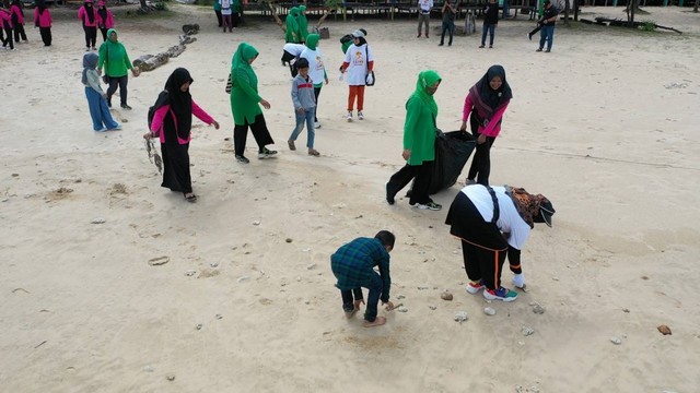 Istri Pj Bupati Aceh Besar (depan) ikut dalam 'Aksi 1 Jam Memungut Sampah’ bersama warga di kawasan wisata Pantai Lampuuk. Foto: Abdul Hadi/acehkini