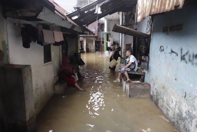 Warga beraktivitas saat banjir yang melanda kawasan Kebon Pala, Jakarta Timur, Senin (10/10/2022). Foto: Iqbal Firdaus/kumparan