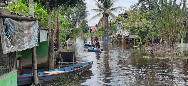 Warga beraktivitas menggunakan sampan karena banjir merendam jalan dan pemukiman di Jalan Darunajah, Kecamatan Sintang. Foto: Yusrizal/Hi!Pontianak