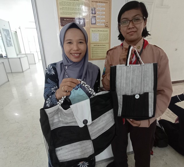 Siti Zuli Roissatun Mutoharo (kiri) bersama salah satu siswinya, Margaretha Elvira Frisnadine, yang membuat tas kain serbaguna berbahan limbah masker medis. Foto: Masruroh/Basra