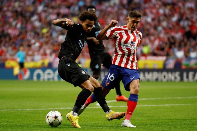 Pemain Atletico Madrid Nahuel Molina berebut bola dengan pemain Club Brugge pada pertandingan Grup B Liga Champions di Metropolitano, Madrid, Spanyol. Foto: Juan Medina/REUTERS