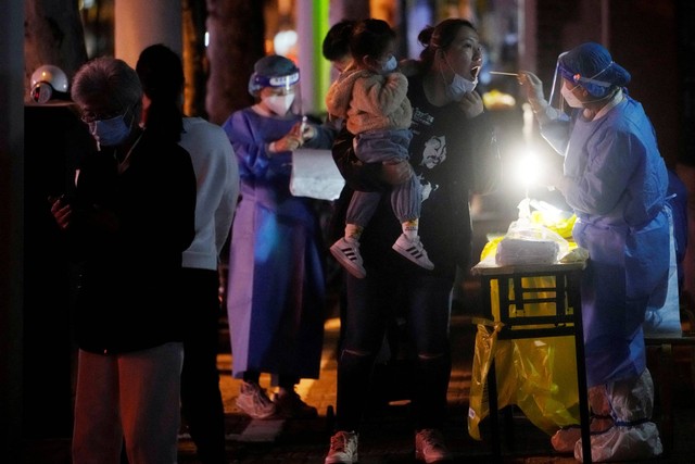 Seorang pekerja medis dengan APD mengumpulkan swab dari seorang warga untuk pengujian COVID-19, di Shanghai, China, Kamis (13/10/2022). Foto: Aly Song/REUTERS