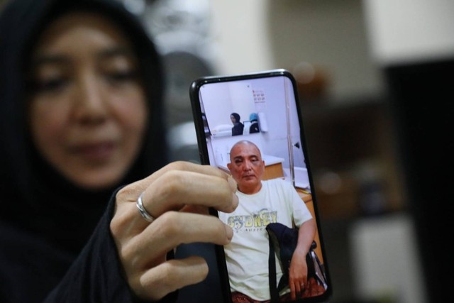 Istri John Jaiz Muhammad, Puti Intan Ageyani Boudewijn, menunjukkan foto suaminya yang luka-luka. Foto: Aditia Noviansyah/kumparan
