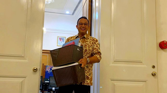 Gubernur DKI Jakarta Anies Baswedan membawa barang-barangnya dari ruangan di Balai Kota DKI Jakarta, Jumat (14/10/2022). Foto: Haya Syahira/kumparan