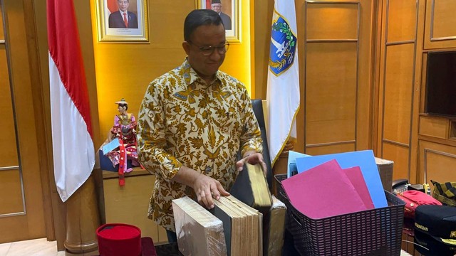 Gubernur DKI Jakarta Anies Baswedan membawa barang-barangnya dari ruangan di Balai Kota DKI Jakarta, Jumat (14/10/2022). Foto: Haya Syahira/kumparan