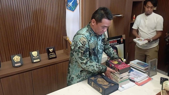 Wakil Gubernur DKI Jakarta Ahmad Riza Patria merapikan beberapa berkas dan buku di ruang kerjanya, Balai Kota Jakarta, Jumat (14/10/2022). Foto: Fadlan/kumparan