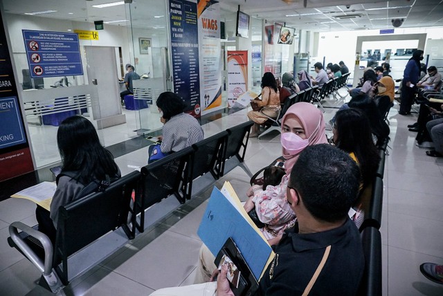 Petugas memotret wajah pemohon paspor saat layanan akhir pekan di Kantor Imigrasi Kelas I Khusus Non TPI Jakarta Selatan, Sabtu (15/10/2022). Foto: Jamal Ramadhan/kumparan