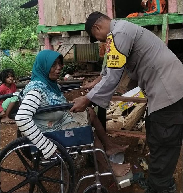Nenek Wa Gia saat mencoba kursi roda yang diberikan oleh Bhabinkamtibmas Aipda Sardin. Foto: Ist