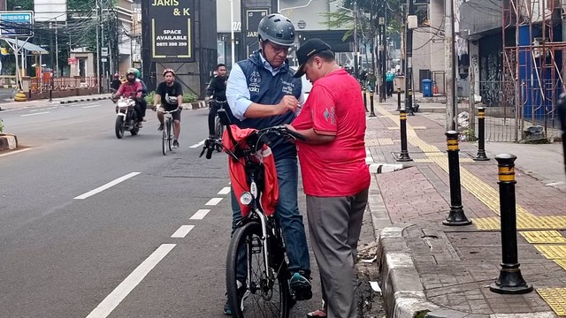 Gubernur DKI Jakarta Anies Baswedan menandatangani kaos salah satu warga di daerah Fatmawati, Jakarta, Minggu (16/10/2022). Foto: Zamachsyari/kumparan