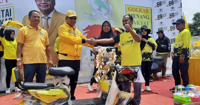 Ketua DPD Partai Golkar Sintang, Usmandy menyerahkan hadiah utama jalan sehat yakni motor listrik pada peserta yang beruntung.(Foto: Yusrizal/Hi! Pontianak)